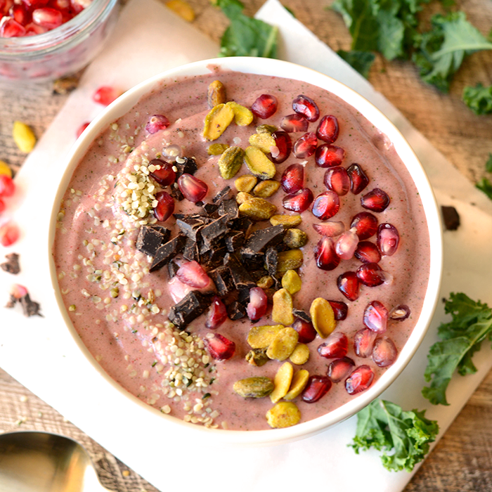 Get fancy with your smoothie and make this delicious pomegranate green smoothie bowl topped with pomegranate arils, pistachios, hemp seeds, and dark chocolate!
