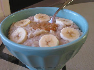 a bowl of oatmeal with bananas and a spoon.