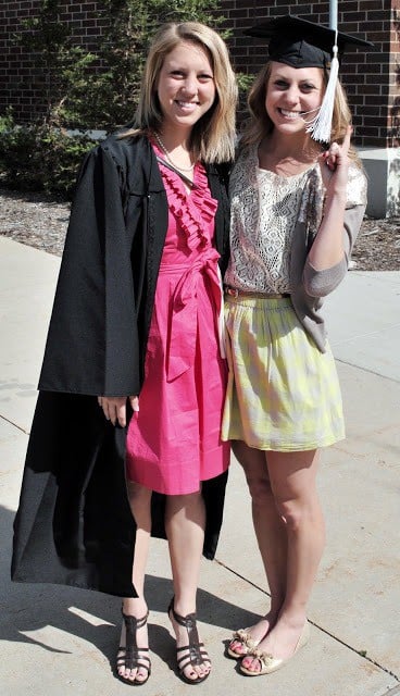 two women posing for a picture in graduation gowns.