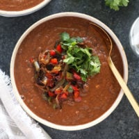 Two bowls of black bean soup on a table.