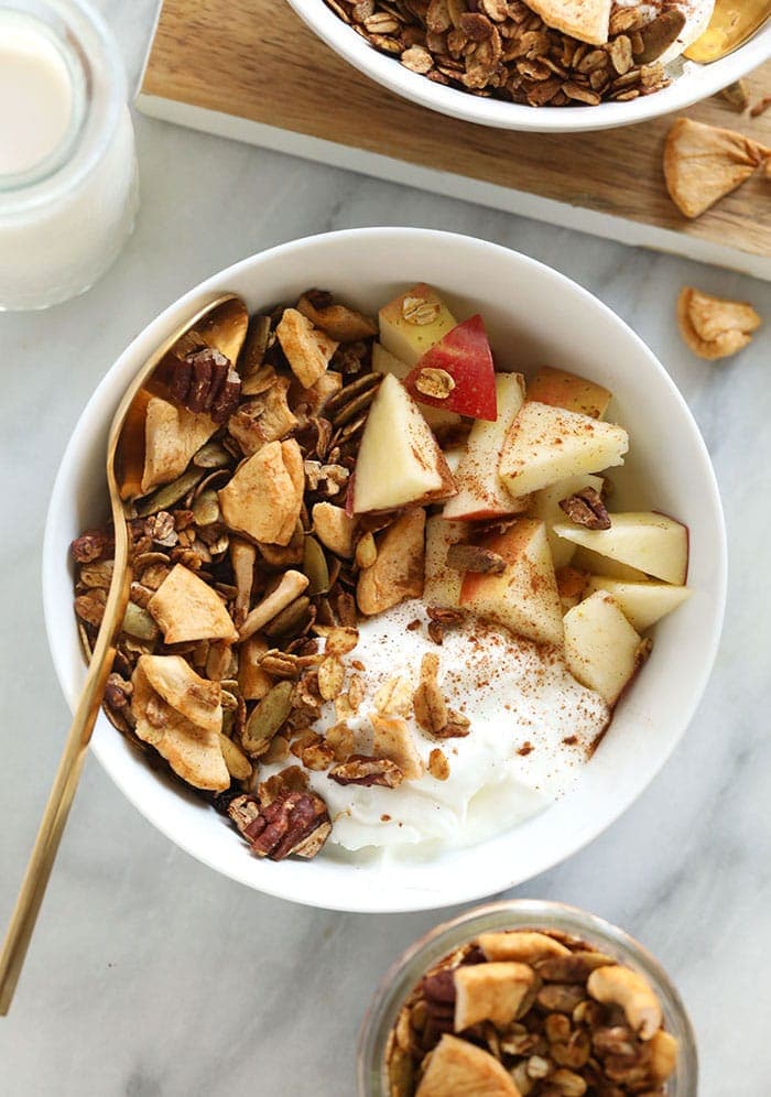 A yogurt parfait with granola and apples.