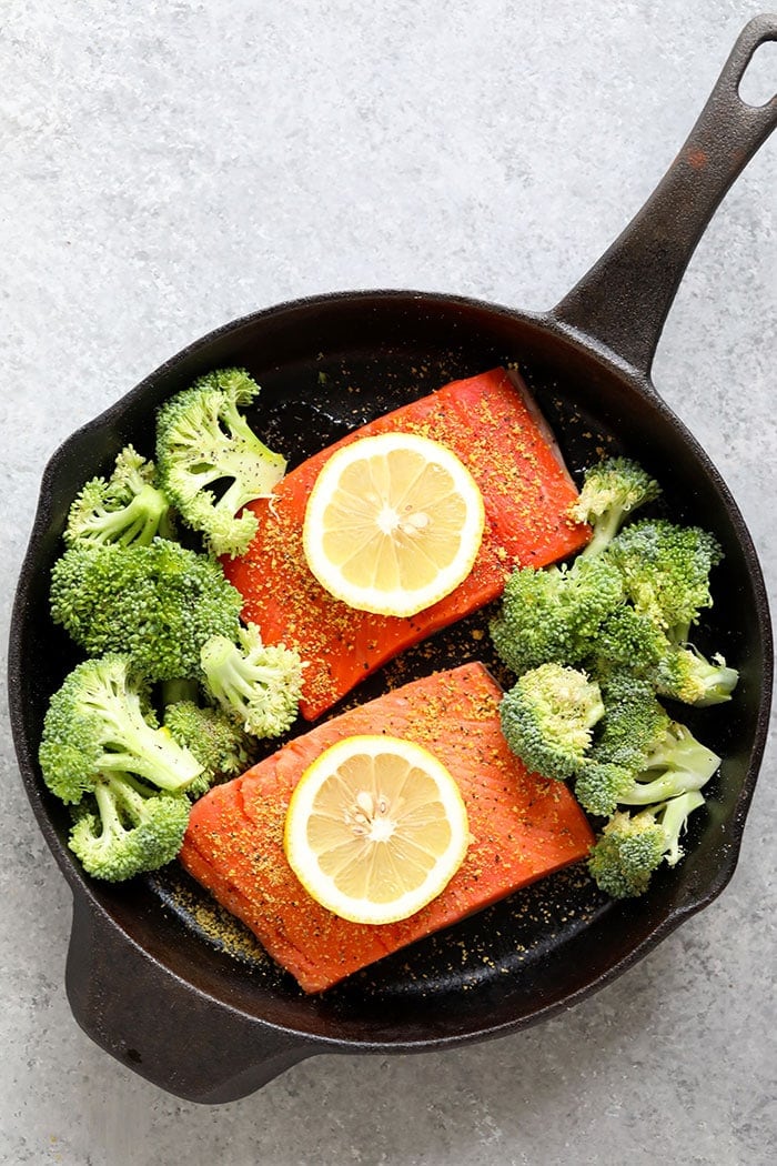 salmon and broccoli with lemon wedges
