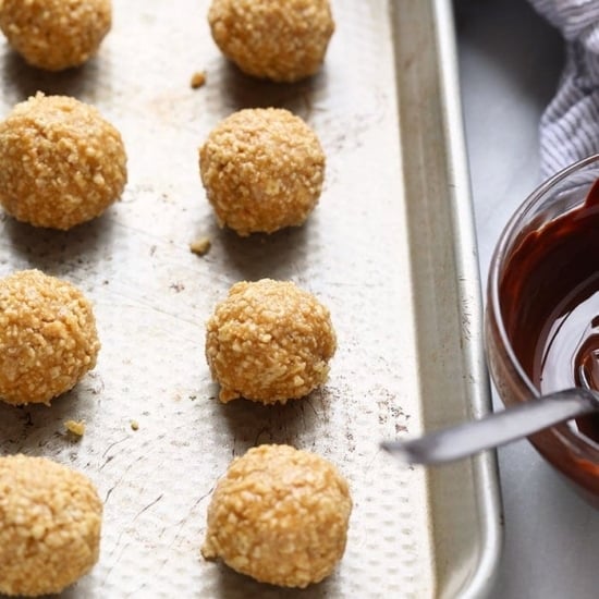 Granola bites on a baking sheet with a bowl of dipping sauce.