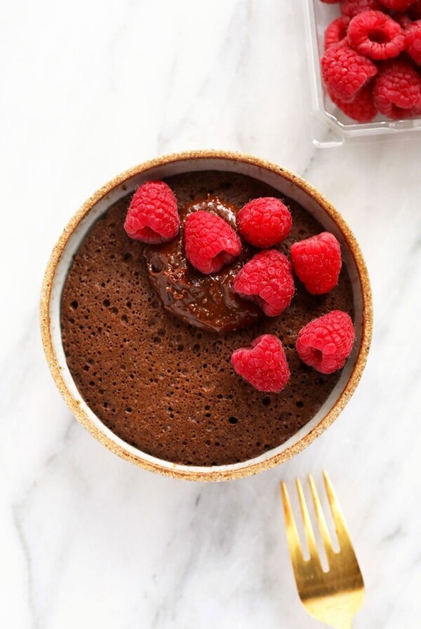 single-serve mug cake topped with delicious raspberries and a homemade chocolate frosting