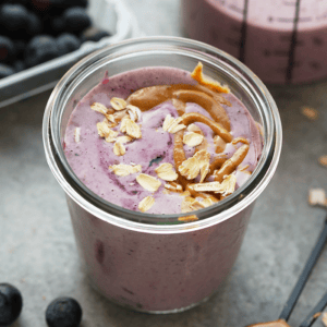 a peanut butter and jelly protein smoothie in a mason jar.
