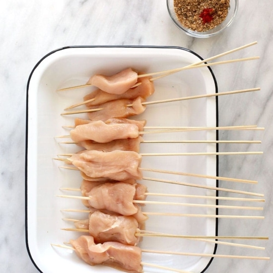 Chicken skewers plated on a white plate.