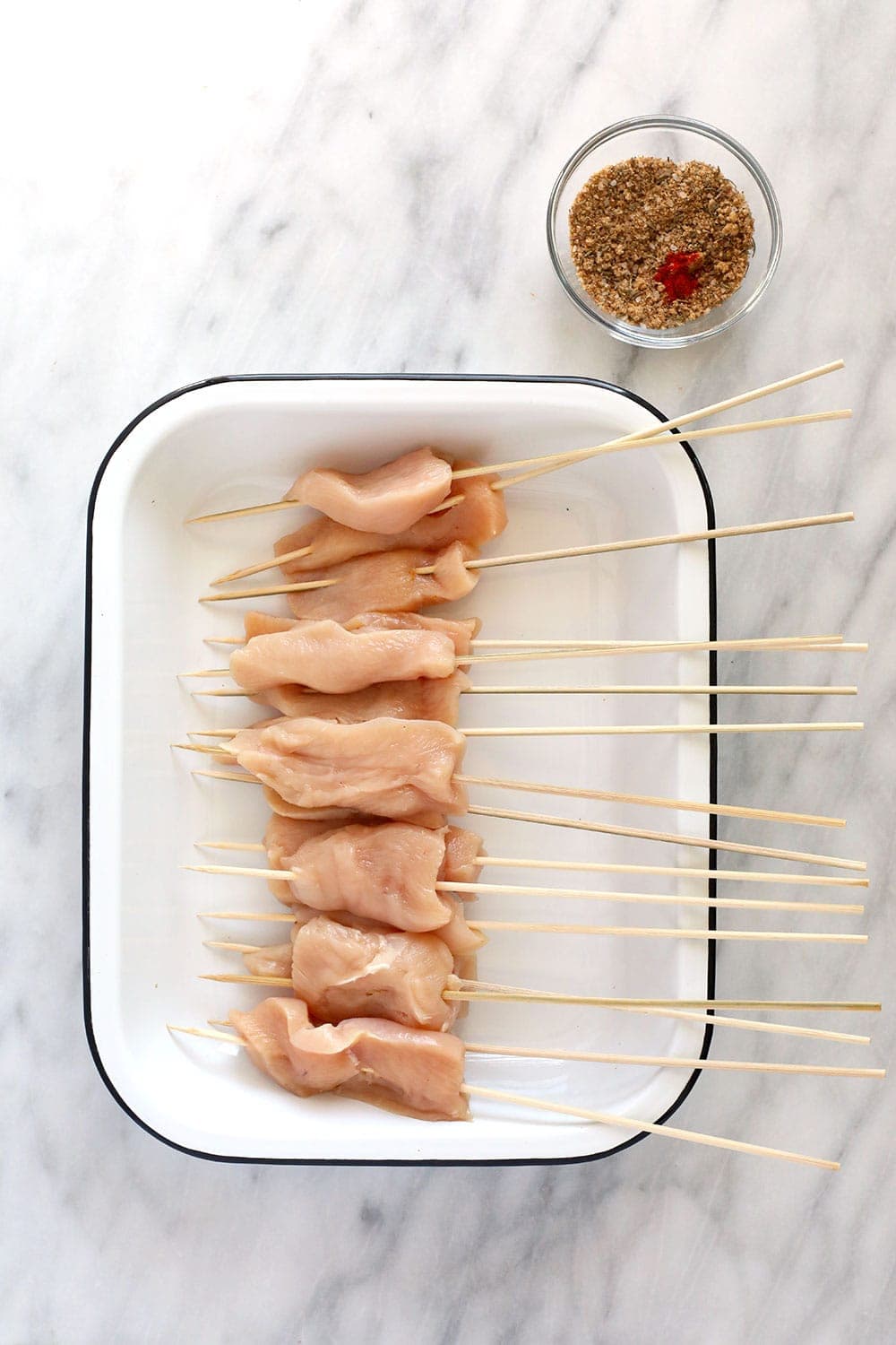 These BBQ Chicken Skewers are the perfect summer meal! Grab some skewers, BBQ sauce, and your favorite BBQ side dish and let's grill! Raw chicken on skewers.