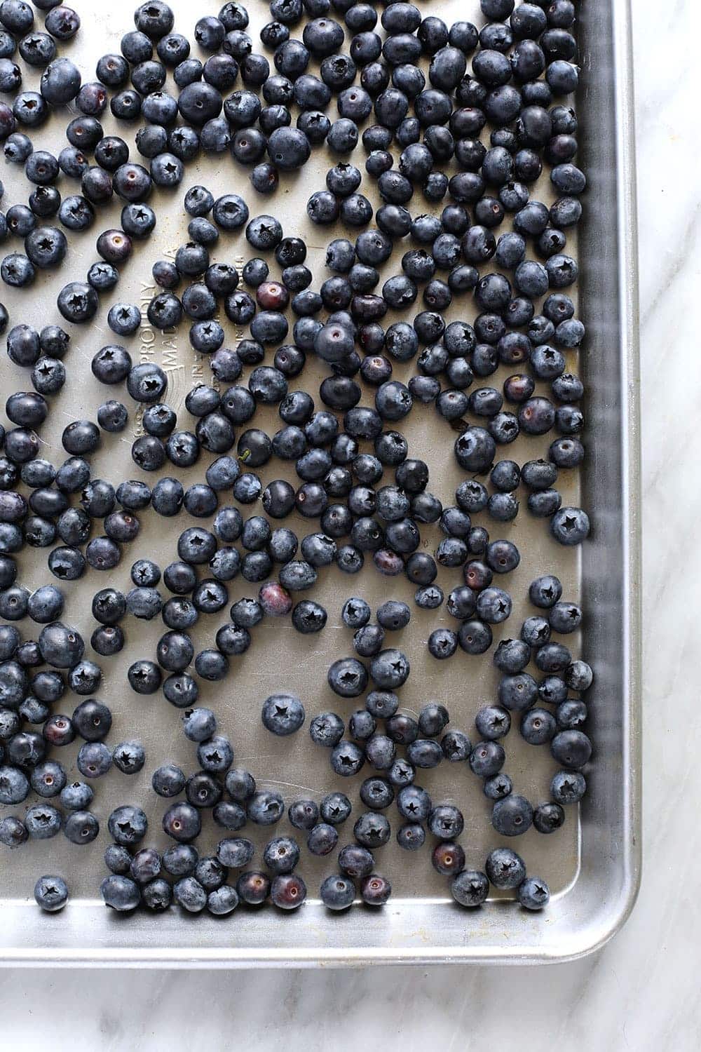 frozen blueberries on a baking sheet