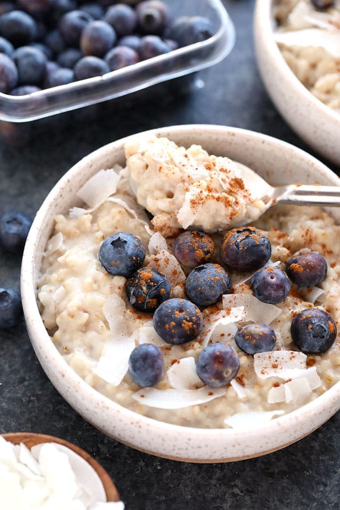 creamy coconut slow cooker steel cut oats in a bowl topped with blueberries