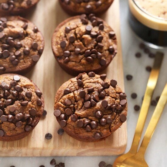 Gluten-free chocolate chip muffins on a wooden cutting board.