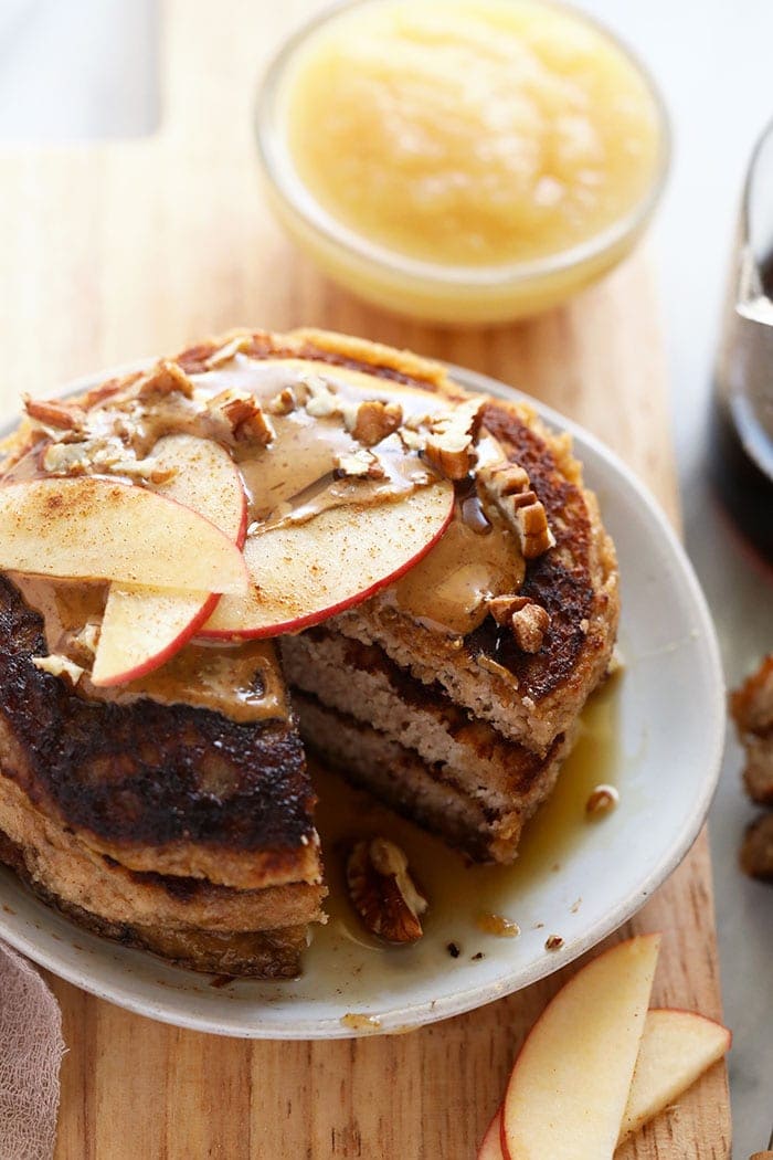 applesauce pancakes on a plate topped with apple slices and nut butter