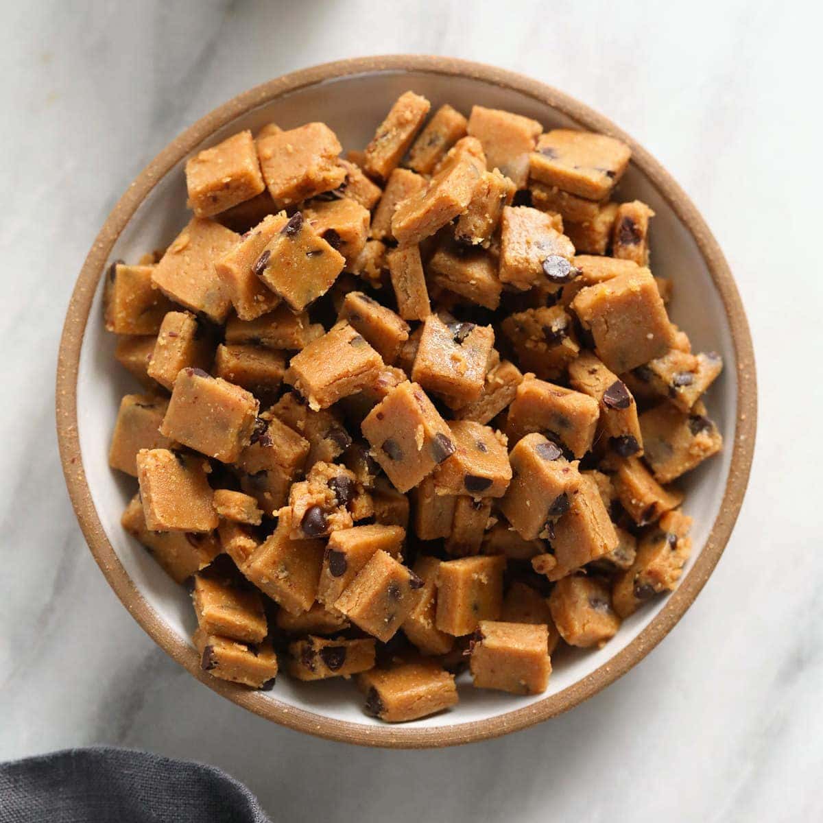 Peanut butter fudge with cookie dough bites in a bowl.
