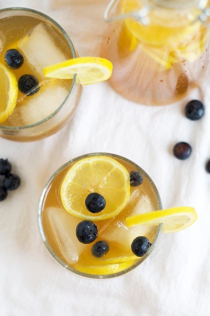 Kombucha Lemonade in two cups with lemons and blueberries