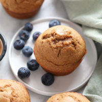 a plate with banana bread muffins and blueberries on it.