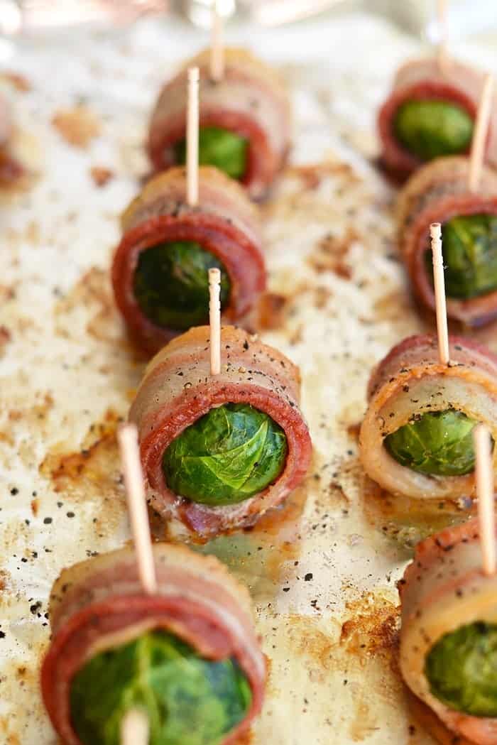 Bacon wrapped brussel sprouts on baking sheet ready to serve with a toothpick.