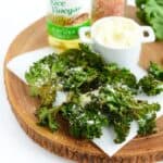 Kale chips on a wooden cutting board.