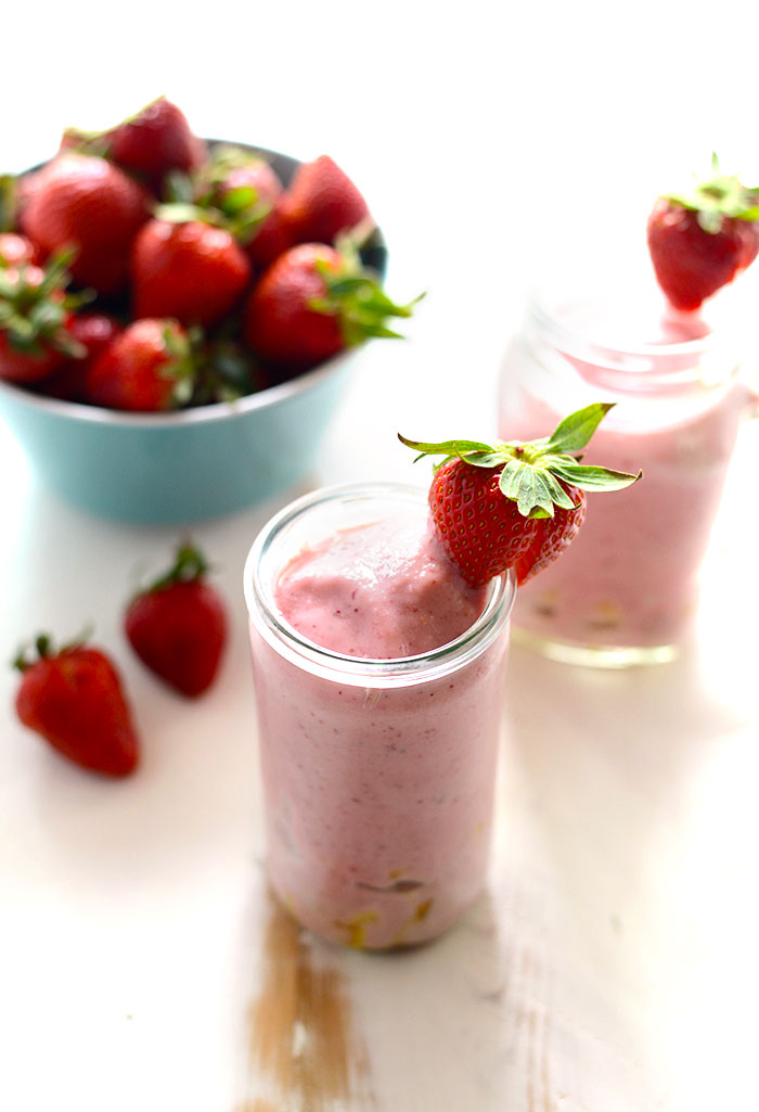 strawberry smoothie with pineapple chunks and whole strawberries in bowl