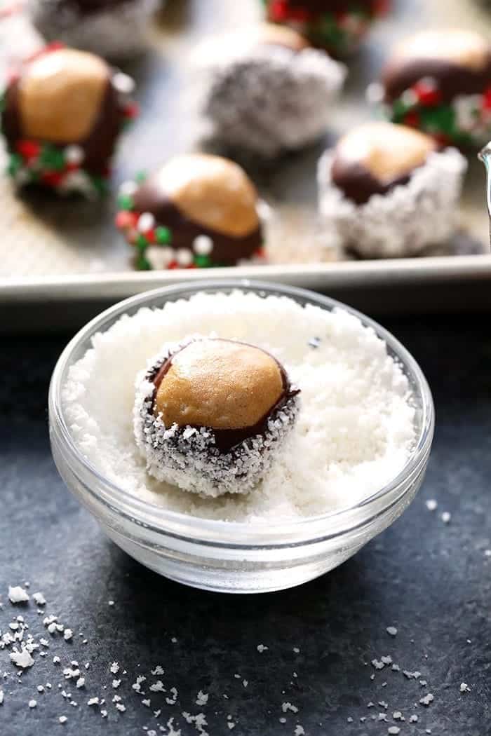 A bowl of healthy chocolate peanut butter truffles on a baking sheet.