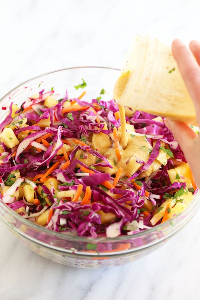 Pouring dressing on coleslaw
