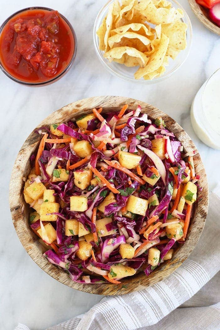 Coleslaw in a bowl with other BBQ sides