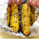 Grilled corn on the cob wrapped in foil.