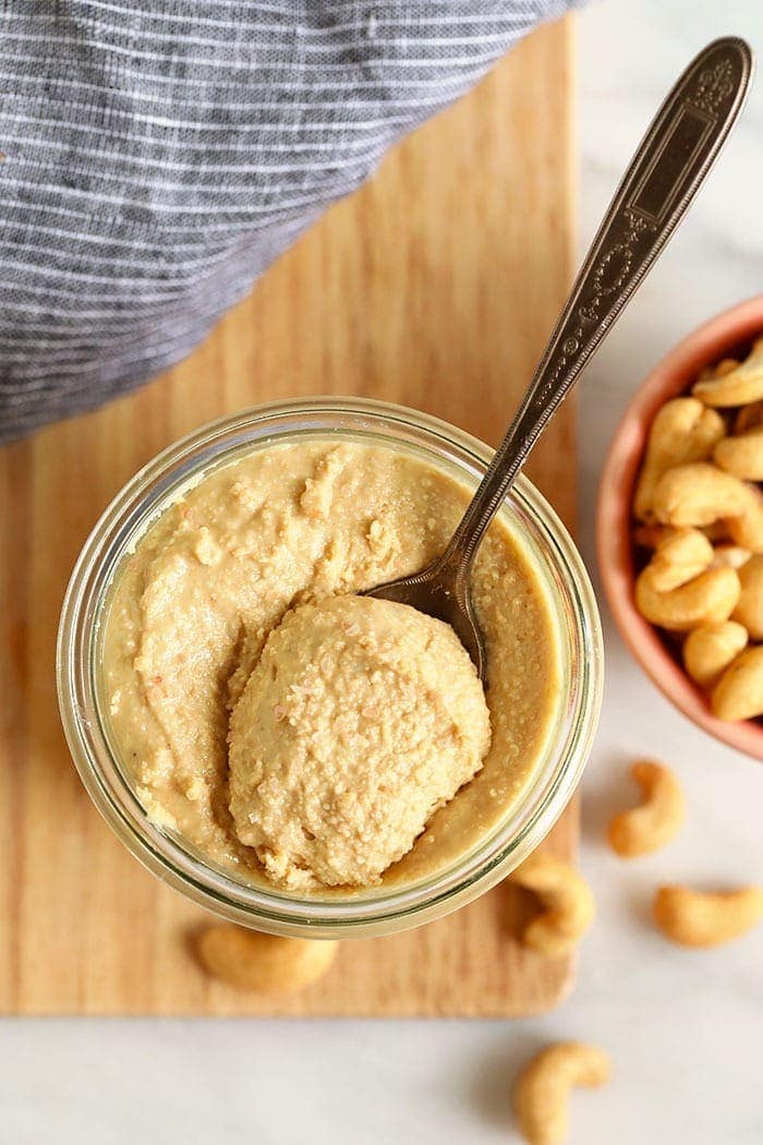 cashews butter in a glass jar with a spoon
