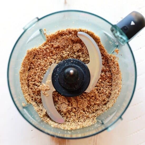 A food processor creating cherry pie energy balls with brown sugar.