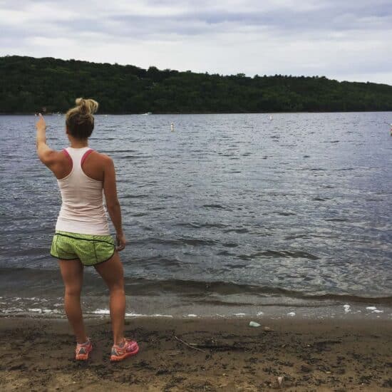 a woman is standing on the shore of the St. Croix River.