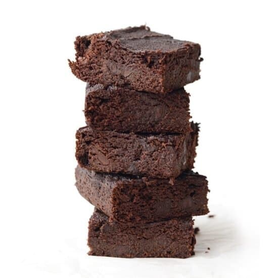 A stack of paleo pumpkin brownies on a white background.