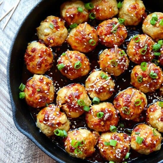 Kung Pao Chicken meatballs cooked in a skillet and served with a fork.