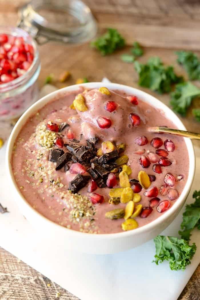 Get fancy with your smoothie and make this delicious pomegranate green smoothie bowl topped with pomegranate arils, pistachios, hemp seeds, and dark chocolate! 