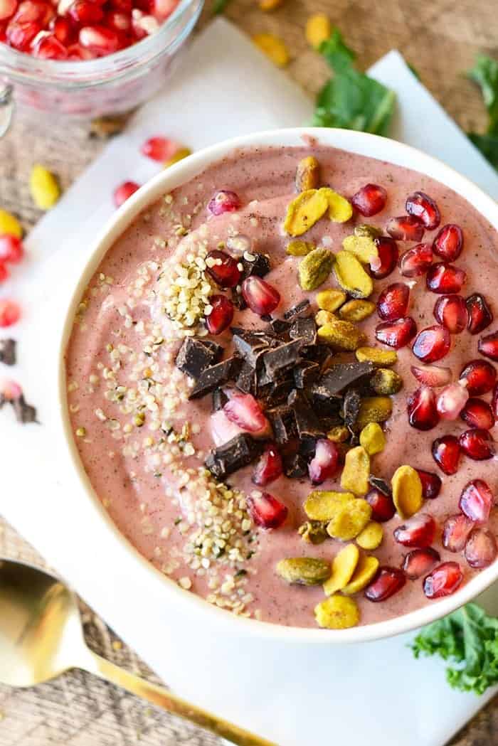 Get fancy with your smoothie and make this delicious pomegranate green smoothie bowl topped with pomegranate arils, pistachios, hemp seeds, and dark chocolate! 