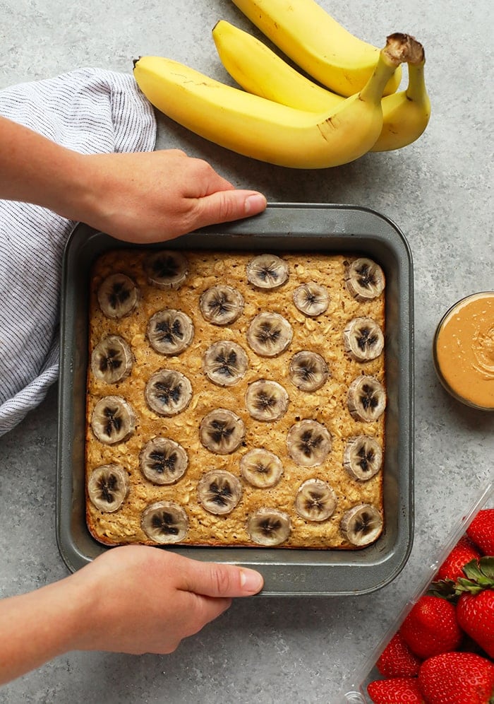 A baked oatmeal dish with banana and peanut butter, topped with strawberries.