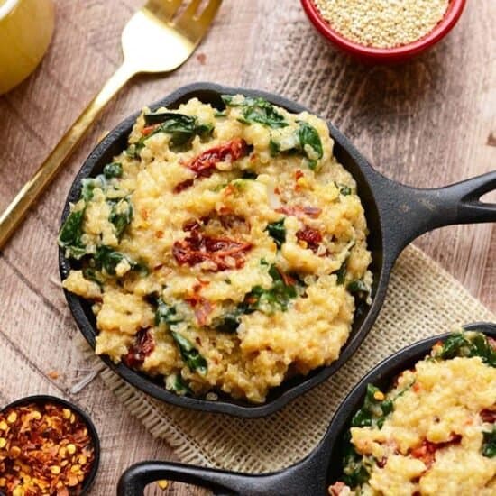 Three bowls of quinoa with spinach, bacon, and a wooden table.