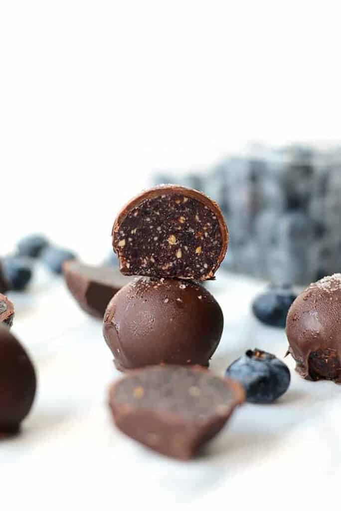 Blueberry truffles on a white surface.