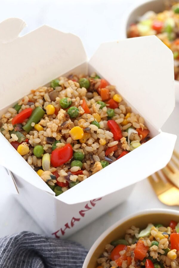 a box of fried rice with vegetables in it.