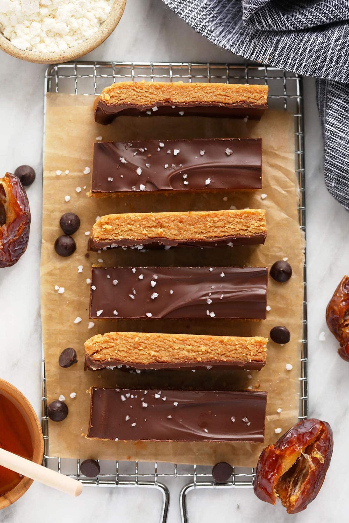 This delicious peanut butter protein bar recipe packs in protein, fiber, and flavor. They're made with real ingredients, but taste like dessert! The kids will love these homemade protein bars! protein bars on wire rack