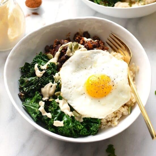a black bean breakfast bowl with rice, kale, and a fried egg.