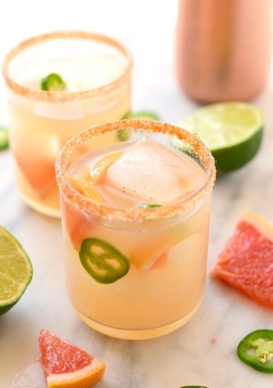 Two glasses of delicious grapefruit margaritas with a hint of jalapeños and tangy limes.