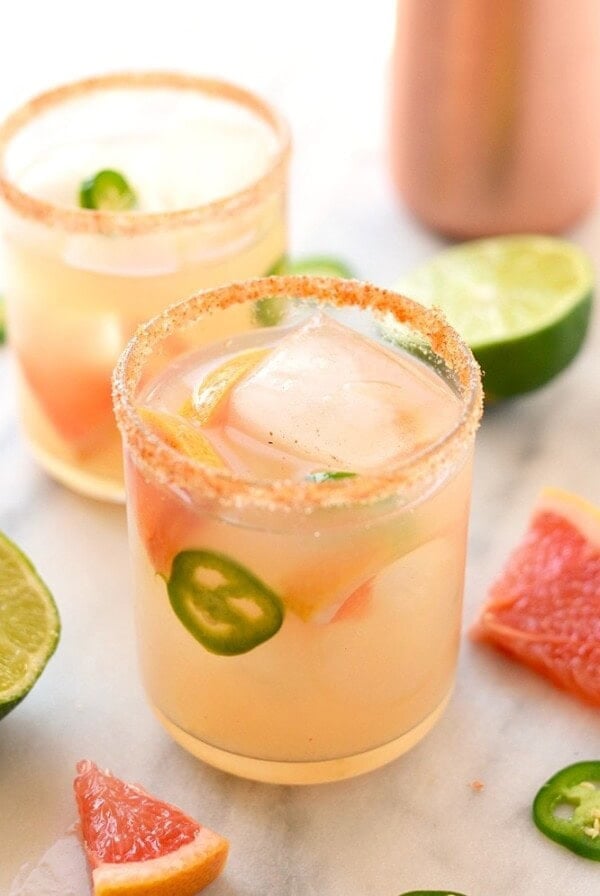 Two glasses of delicious grapefruit margaritas with a hint of jalapeños and tangy limes.