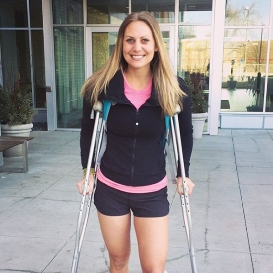 a woman with crutches standing in front of a building.