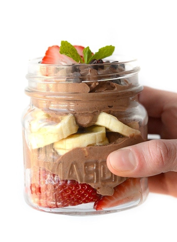 healthy chocolate peanut butter mousse as a parfait with sliced strawberries and sliced bananas