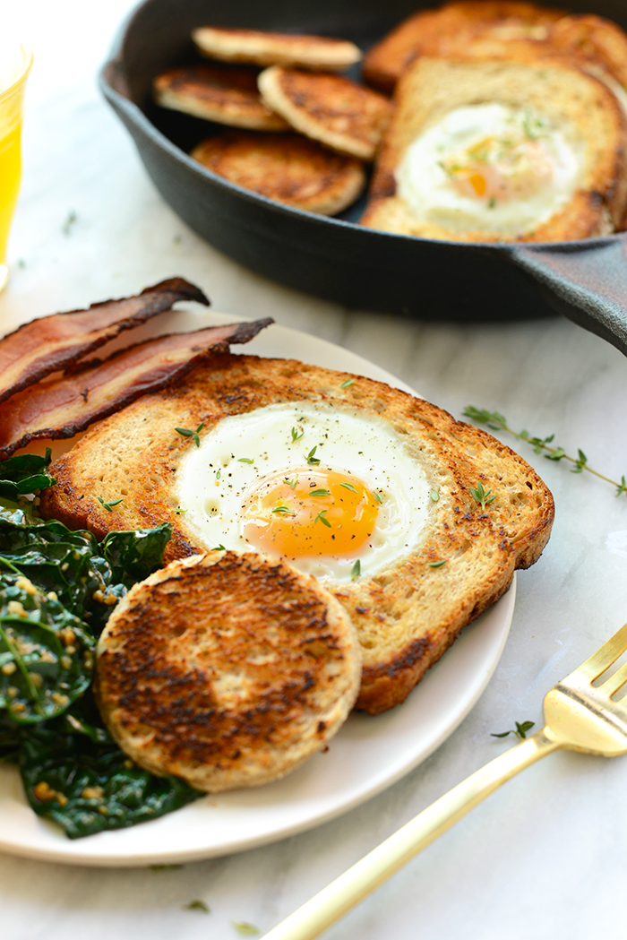 egg in a hole on plate with bacon