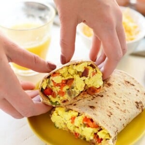 a person is preparing a nutritious burrito with eggs.