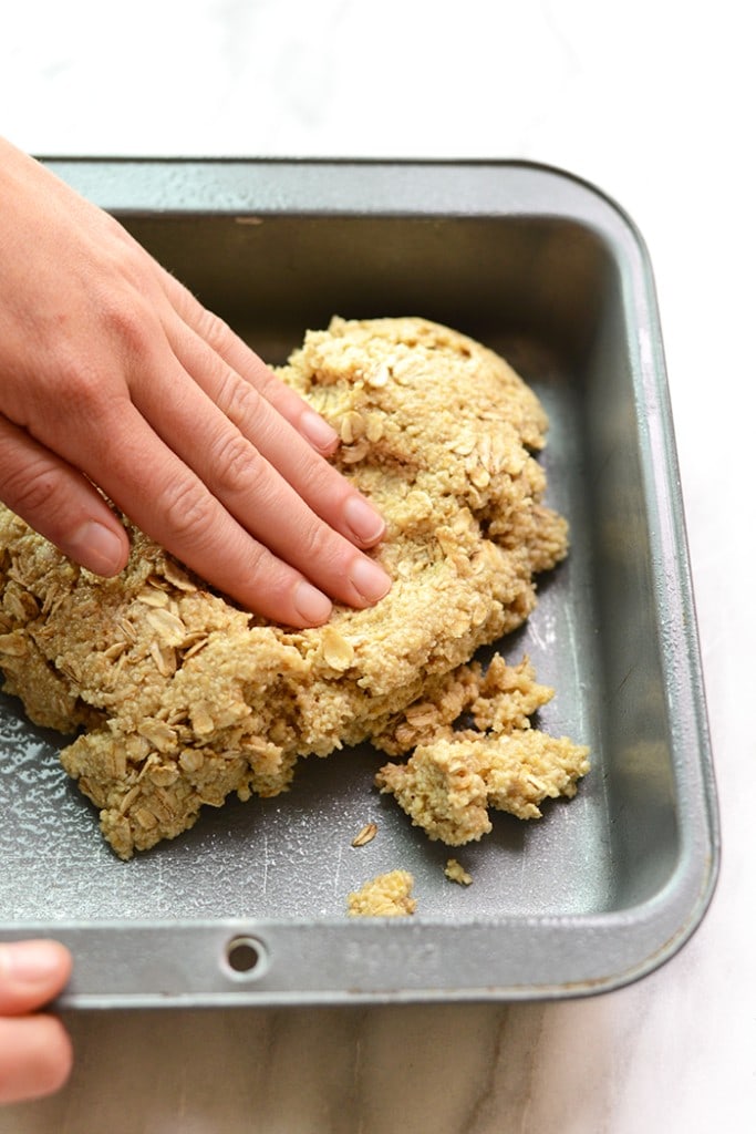 Pushing the almond flour crust into the pan. 