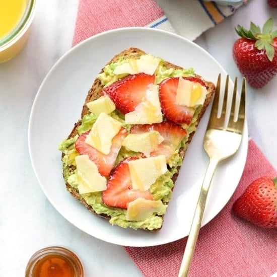 White cheddar toast with avocado and strawberries.