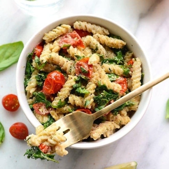 A creamy vegan pasta salad with tomatoes and basil.