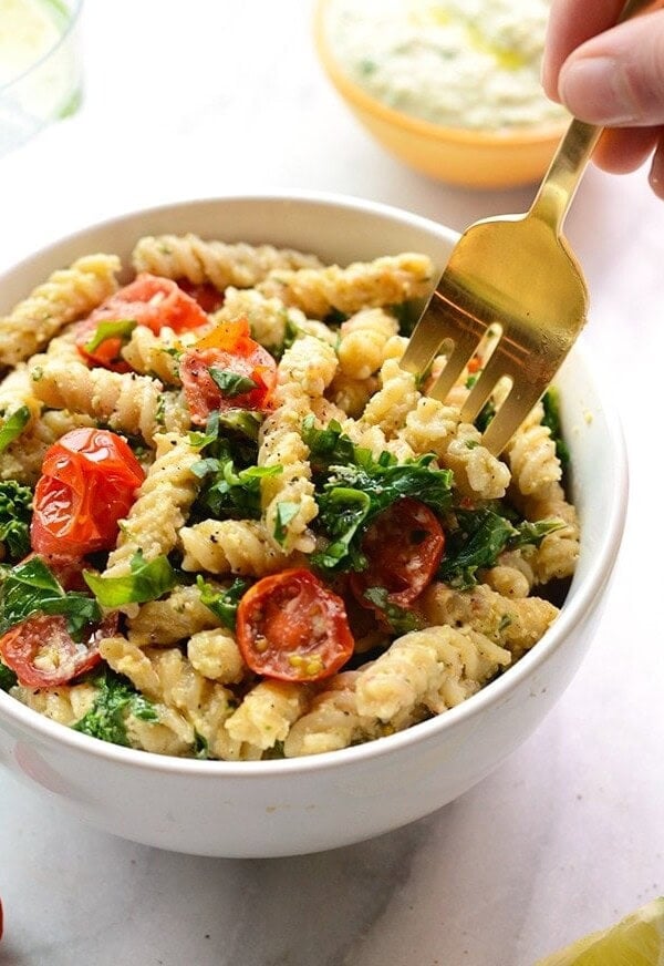 Creamy vegan pasta salad with tomatoes and kale.