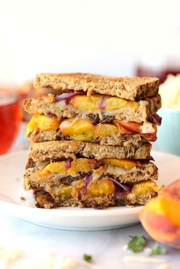 A plate of grilled peach sandwiches, with gouda cheese.
