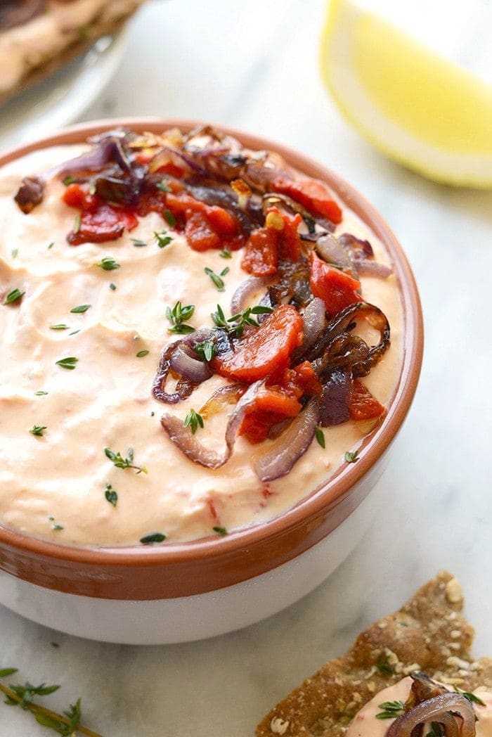 With Sunday football back in action, this Skinny Roasted Red Pepper and Goat Cheese Dip makes for the most perfect appetizer. It's made with a non-fat Greek yogurt base, pureed roasted red peppers, and goat cheese! 